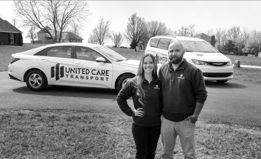 Jordan & Chance standing in front of united car transport vehicles